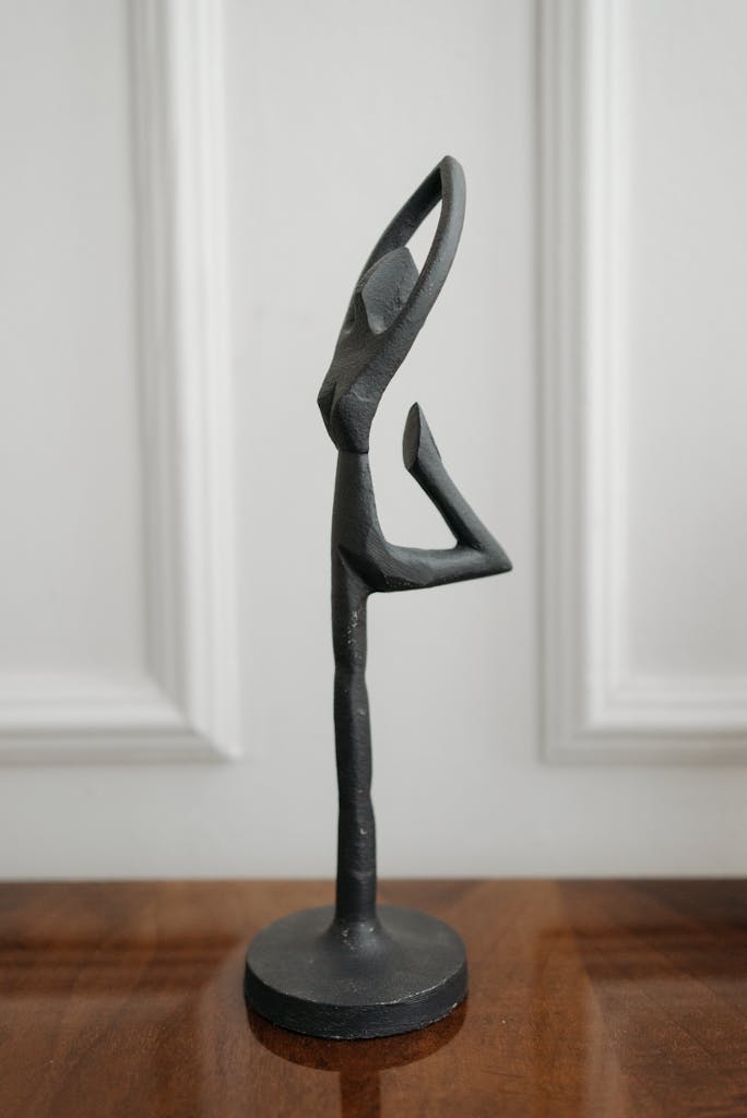 Artistic metallic sculpture depicting an elegant dancer on a white background.